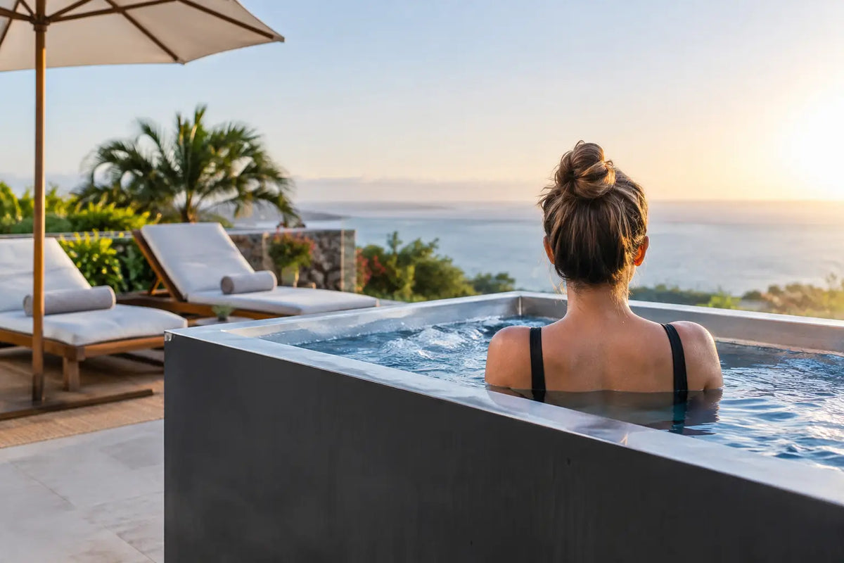 Resort cold plunge tub with ocean view, guest relaxing at sunset overlooking the water